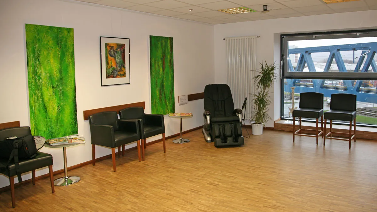 Wartezimmer der Chiropraxis mit Massagesessel und großem Fenster
