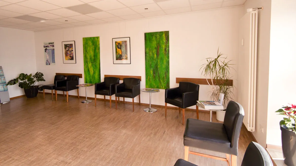 Wartezimmer der Chiropraxis mit grünen Wandbildern